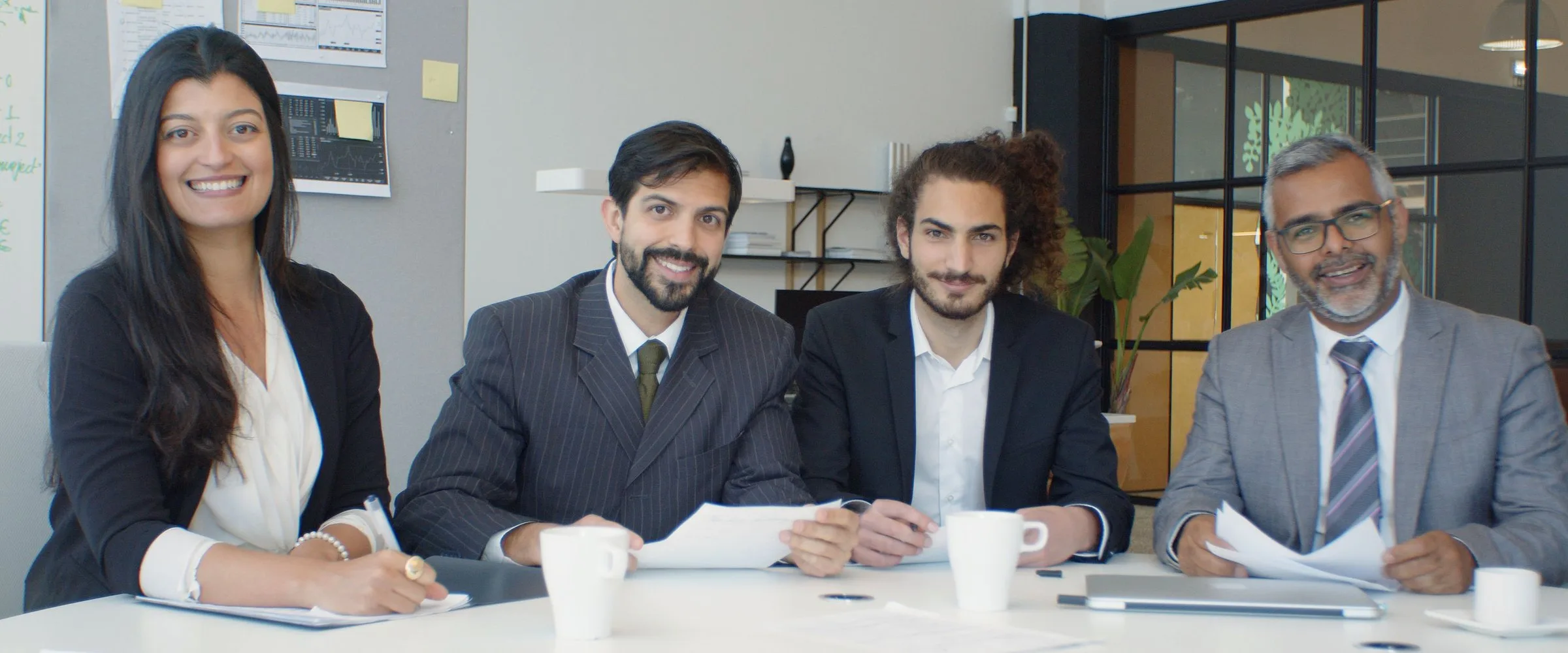 A smiling team of counsellors around a meeting table