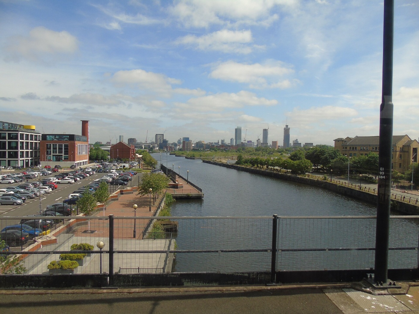 A canal in Manchester with the city centre skyline in the distance