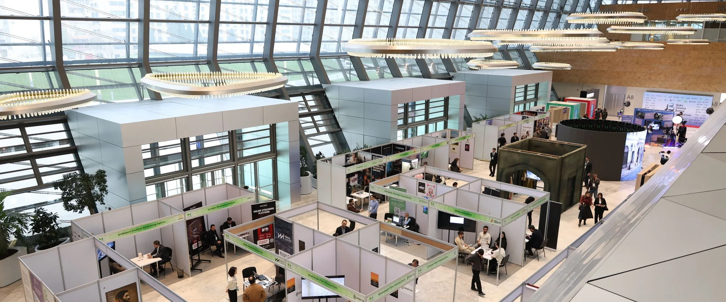 A busy education expo hall with university stands and visitors