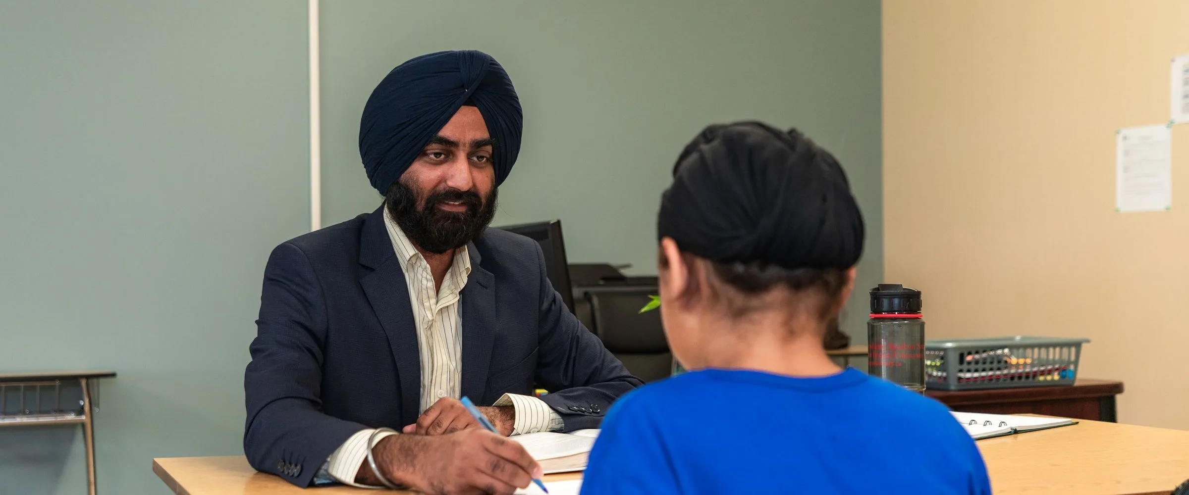 An admissions officer reviewing a student's documents at a desk