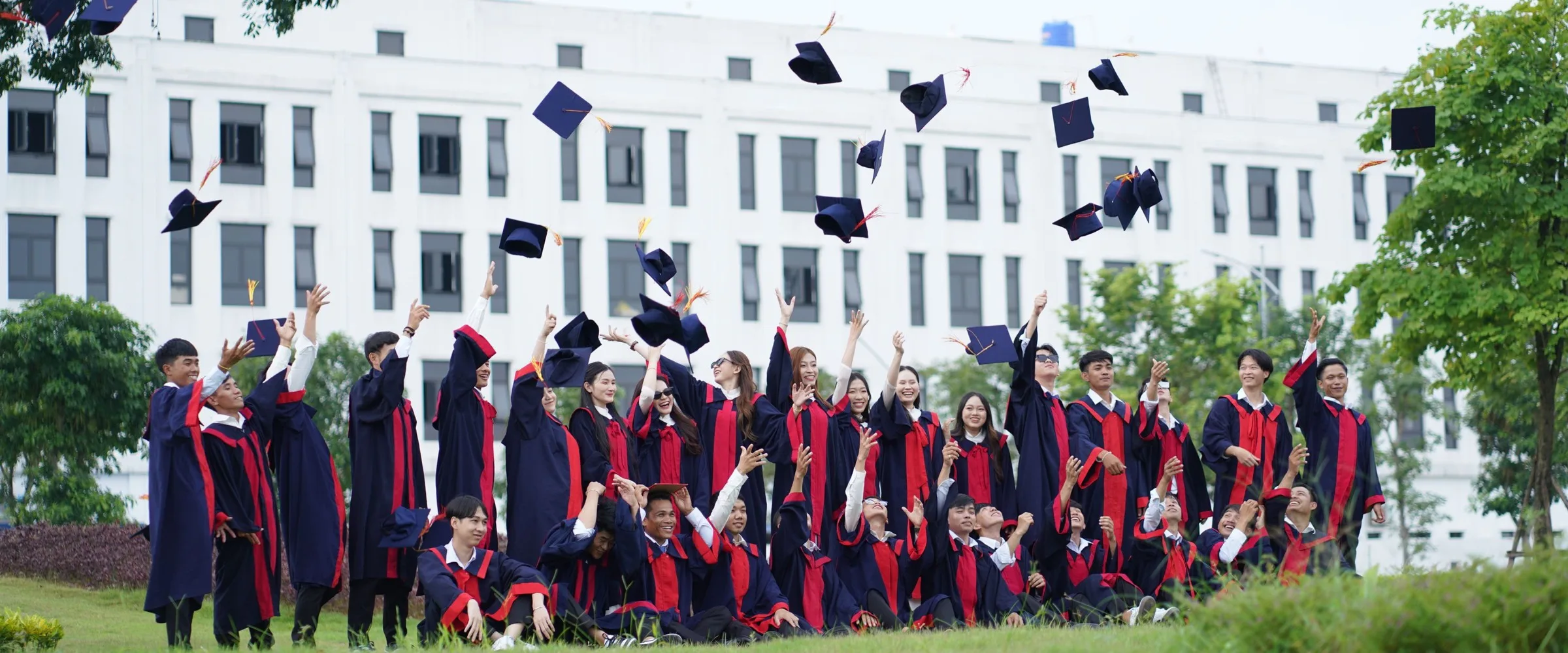 Graduates throwing their caps in the air outside a university building
