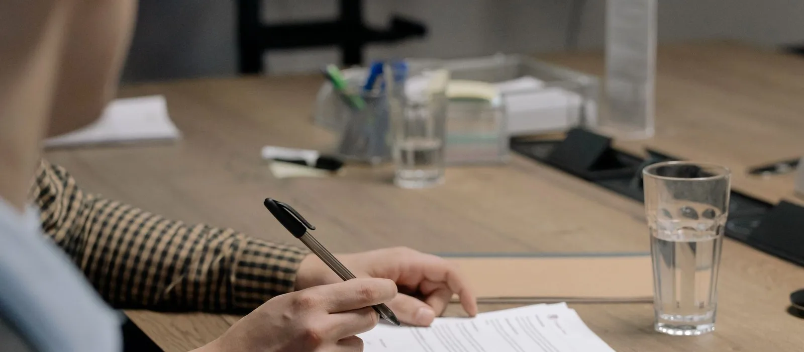 A person signing a document at a desk
