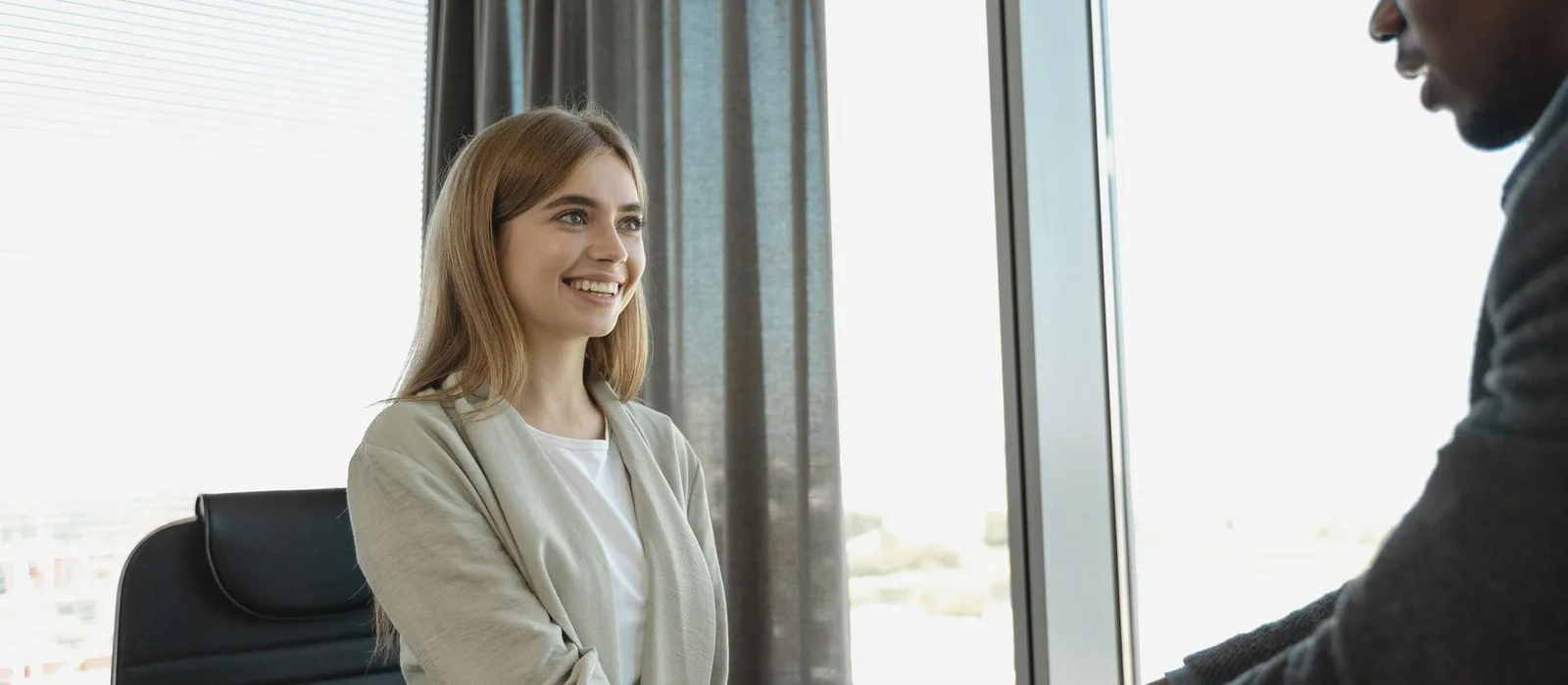 A smiling candidate in an interview in a bright office